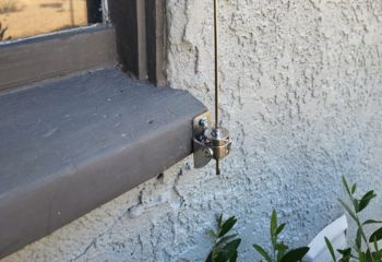 Close-up view of the cable mechanism for installed electric custom roller shades at a South Pasadena home